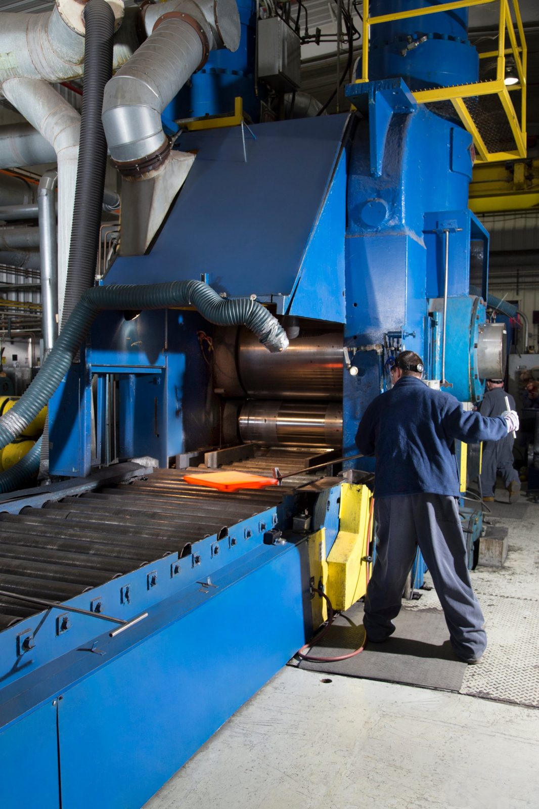 Operator guiding a hot plate into a rolling mill