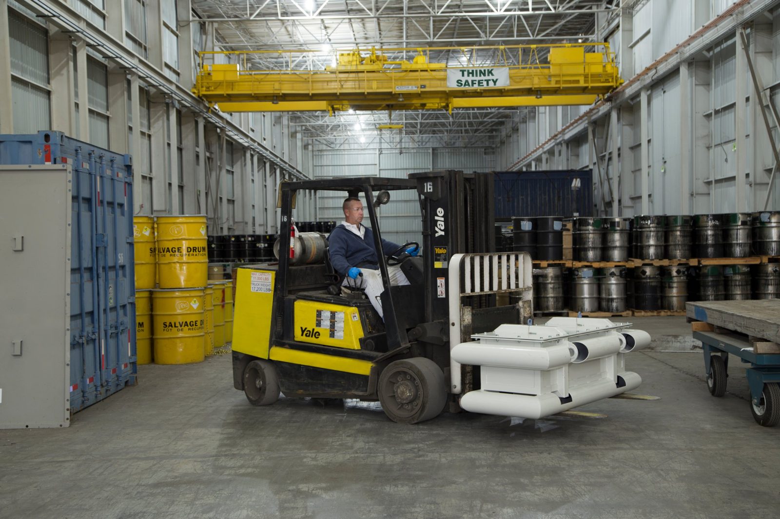 Forklift operator moving a container under a Think Safety overhead crane